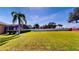 Expansive backyard featuring a lush green lawn, privacy fence, and view of the screened-in pool area at 1855 Sugar Cove Ct, Ocoee, FL 34761