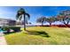 Spacious backyard with green grass, a mature palm, and a screened-in pool area at 1855 Sugar Cove Ct, Ocoee, FL 34761