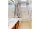 Bright bathroom with a shower and tub combination, safety bars, and white tiled walls at 1855 Sugar Cove Ct, Ocoee, FL 34761