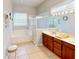 Bright bathroom with double vanity, large mirror, soaking tub, and separate glass-enclosed shower at 1855 Sugar Cove Ct, Ocoee, FL 34761