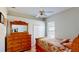 Cozy bedroom with a ceiling fan, closet, wood-look floors, and a wooden dresser with mirror at 1855 Sugar Cove Ct, Ocoee, FL 34761