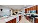 Spacious kitchen with stainless steel appliances, custom wood cabinets and a breakfast bar overlooking the living area at 1855 Sugar Cove Ct, Ocoee, FL 34761