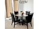 Dining room with glass-top table, four black chairs, and beige curtains at 2058 Derwent Dr, Davenport, FL 33896