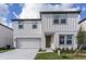 Two-story house with white siding, gray accents, and a two-car garage at 2058 Derwent Dr, Davenport, FL 33896