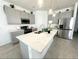 Modern kitchen with gray cabinets, stainless steel appliances, and a large island at 2058 Derwent Dr, Davenport, FL 33896