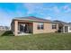 House exterior showcasing backyard patio and green lawn at 2128 Silver Brook Way, Davenport, FL 33837