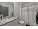Well-lit bathroom featuring granite countertop, white cabinets, and shower at 2128 Silver Brook Way, Davenport, FL 33837