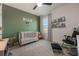 Charming Bedroom with green accent wall, crib, and rocking chair at 2128 Silver Brook Way, Davenport, FL 33837