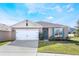 One-story home with white garage door, teal front door, and landscaped lawn at 2128 Silver Brook Way, Davenport, FL 33837