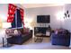 Living room with Mickey Mouse curtains, comfy sofas, and a large TV at 227 Verona Ave, Davenport, FL 33897