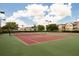 Two tennis courts with red clay surface and green perimeter at 2300 Butterfly Palm Way # 205, Kissimmee, FL 34747