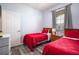 Twin bedroom with red bedding and wood floors at 2300 Butterfly Palm Way # 205, Kissimmee, FL 34747