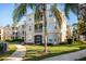 Tan building exterior with palm trees and landscaped grounds at 2300 Butterfly Palm Way # 205, Kissimmee, FL 34747