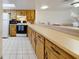 Kitchen featuring bar seating and white tiled flooring with a window for natural light at 2626 S Atlantic Ave # 102, Daytona Beach Shores, FL 32118