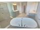 A well-lit bathroom with a glass shower, tub, and vanity sinks at 2678 Great Heron Ave, St Cloud, FL 34773