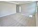 Expansive bedroom with plush carpeting, tray ceiling, and a view of natural light highlighting a serene retreat at 2678 Great Heron Ave, St Cloud, FL 34773