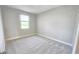 Clean, empty bedroom with neutral carpet, one window, and base molding at 2678 Great Heron Ave, St Cloud, FL 34773