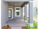 A covered front porch features columns, brick flooring, and a dark wood front door, a welcoming entrance at 2678 Great Heron Ave, St Cloud, FL 34773