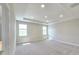 A spacious main bedroom with a tray ceiling, plush carpet, and multiple windows at 2678 Great Heron Ave, St Cloud, FL 34773