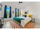Bright bedroom with a yellow bed and teal blanket, two windows at 2735 Calabria N Ave, Davenport, FL 33897