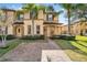 Two-story townhome with brick paver driveway and landscaping at 2735 Calabria N Ave, Davenport, FL 33897