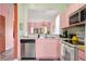 Charming kitchen with pink cabinets and modern appliances at 2735 Calabria N Ave, Davenport, FL 33897