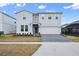 Two-story house with gray siding, paver driveway, and landscaping at 3083 Mahalo Dr, Davenport, FL 33897