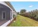 Landscaped backyard with a grassy area and hedge for privacy at 3237 River Branch, Kissimmee, FL 34741