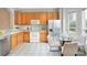 Eat-in kitchen with wooden cabinets, white appliances, and tiled floors at 3237 River Branch, Kissimmee, FL 34741