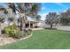 Large grassy backyard with palm trees and a view of the patio and house at 5530 Cypress Hill Rd, Winter Garden, FL 34787