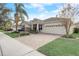 Tan house with a large driveway and palm trees at 5530 Cypress Hill Rd, Winter Garden, FL 34787