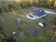 Aerial view of a house with a pool, garden, and outbuildings on a large lot at 720 Napoli Ln, New Smyrna Beach, FL 32168