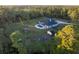 Aerial view showing a house, pool, garden, and outbuildings in a wooded setting at 720 Napoli Ln, New Smyrna Beach, FL 32168