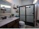 Small bathroom with single vanity, toilet and shower, and a decorative mirror at 720 Napoli Ln, New Smyrna Beach, FL 32168