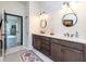 Double vanity bathroom with dark brown cabinets and white subway tile at 720 Napoli Ln, New Smyrna Beach, FL 32168
