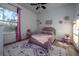 Cozy bedroom with a full-size bed, pink accents, and a ceiling fan at 720 Napoli Ln, New Smyrna Beach, FL 32168