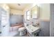 Bathroom with pink tub, white sink, and gray tile walls at 120 Sunset Blvd, Polk City, FL 33868