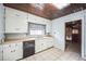 Kitchen with white cabinets, dishwasher, and checkered window curtains at 120 Sunset Blvd, Polk City, FL 33868