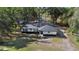 Aerial view of a house with a black roof and white siding, surrounded by trees at 1260 Lake Helen Osteen Rd, Lake Helen, FL 32744