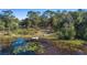 Aerial view of a property with a lake featuring a dock and lily pads at 1260 Lake Helen Osteen Rd, Lake Helen, FL 32744