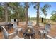 Fire pit surrounded by chairs, wooded backyard at 1260 Lake Helen Osteen Rd, Lake Helen, FL 32744