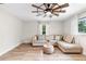 Living area with L-shaped sofa, wood-look floors, and ceiling fan at 1260 Lake Helen Osteen Rd, Lake Helen, FL 32744