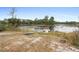 Small pond with dock, boat and wooded area at 1260 Lake Helen Osteen Rd, Lake Helen, FL 32744