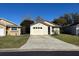 White one-story house with attached garage and small yard at 138 Meadow Blvd, Sanford, FL 32771