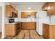 Modern kitchen with light wood cabinets, stainless steel appliances, and white countertops at 1413 Evangeline Ave, Orlando, FL 32809