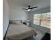 Bedroom featuring a ceiling fan and a window with natural light, plus black metal bedframe at 1490 11Th Ave, Deland, FL 32724