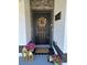 Close up view of a decorated front door with wreath, lanterns, fresh pink flowers, and attractive accents at 1490 11Th Ave, Deland, FL 32724