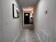 Hallway with entryway decor including mirror, lamp, and decorative table, plus front door at the end of the hall at 1490 11Th Ave, Deland, FL 32724