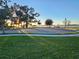 Peaceful lakeside park with a paved pathway and benches at sunset at 15783 Tangerine Dream Ct, Winter Garden, FL 34787