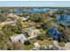 An aerial view showcases the home, pool, and surrounding landscape near the lake at 1715 Concert Rd, Deltona, FL 32738